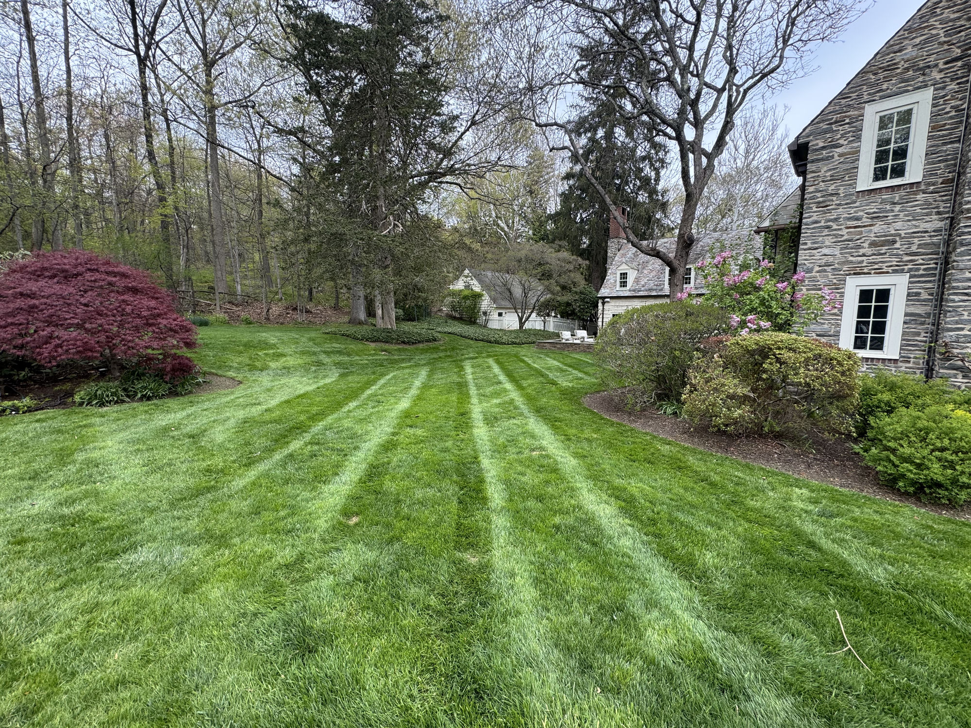 Stone house with manicured striped lawn