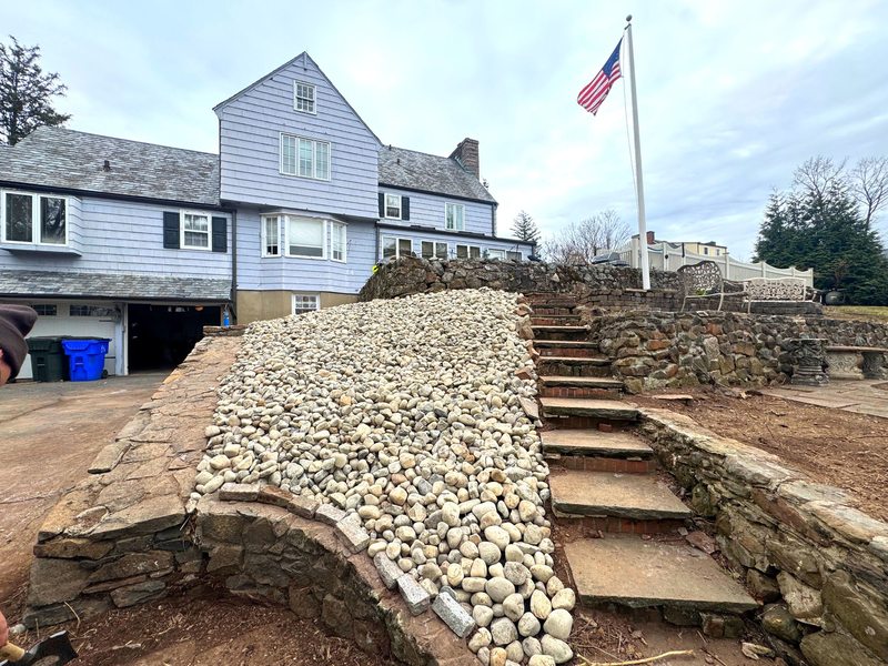Stone retaining wall and steps installed at a residential property